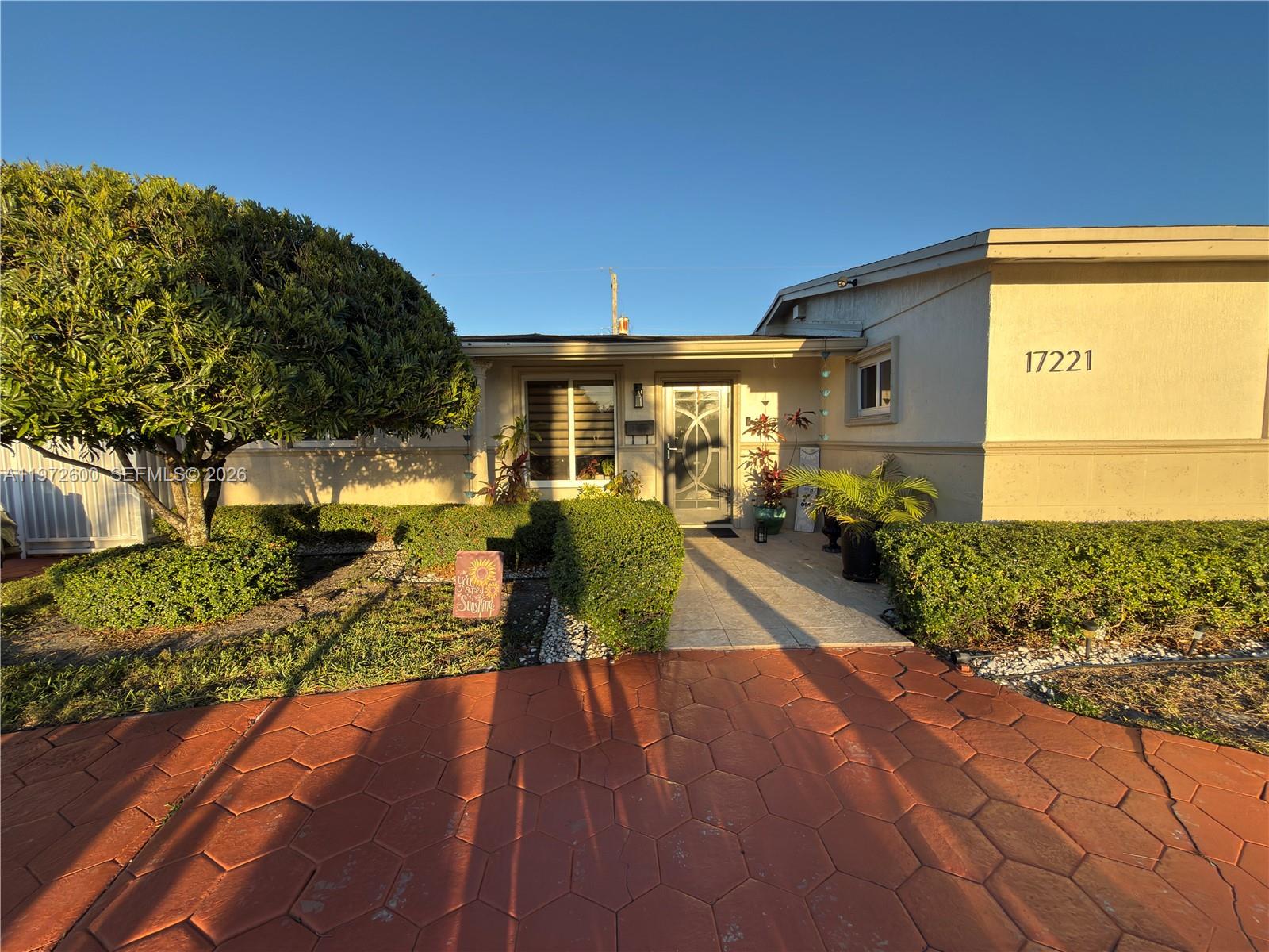 A single-story house features a red hexagonal paver driveway, manicured hedges, and a front entrance — 17221 NW 82nd Ave, Hialeah FL 33015, HIALEAH, FL