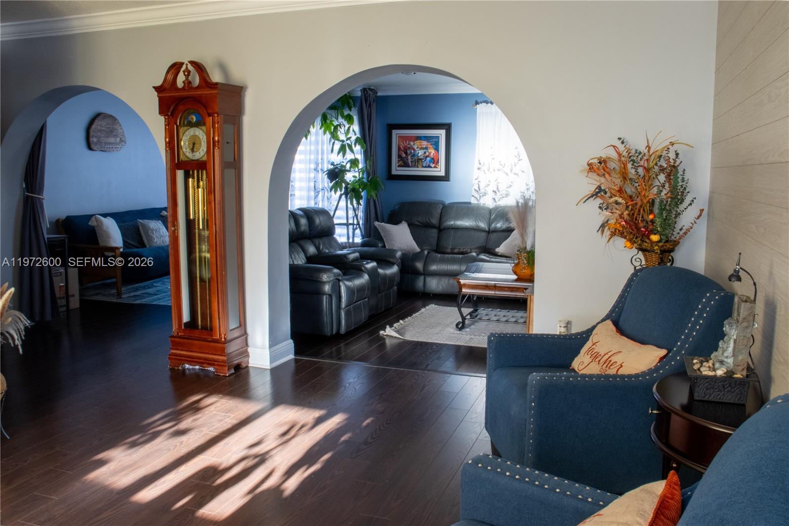 A living room features arched doorways, dark wood flooring, and a tall grandfather clock — 17221 NW 82nd Ave, Hialeah FL 33015, HIALEAH, FL