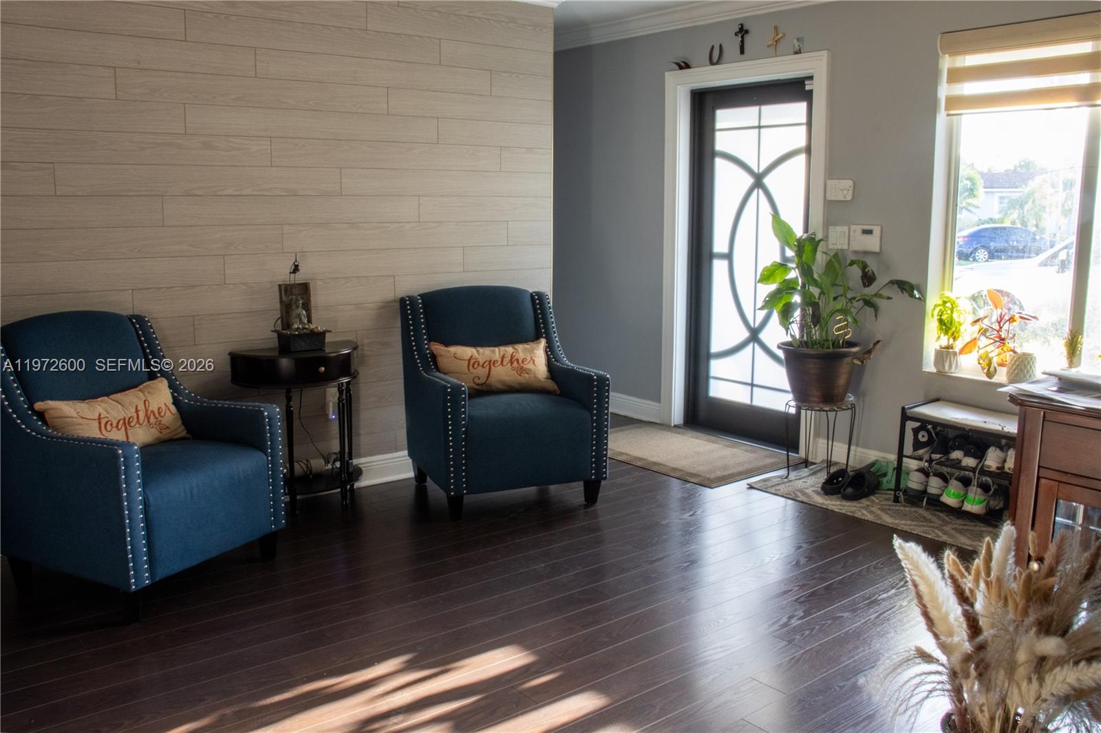 A living room features dark wood floors, two blue armchairs, and a light wood-paneled wall — 17221 NW 82nd Ave, Hialeah FL 33015, HIALEAH, FL