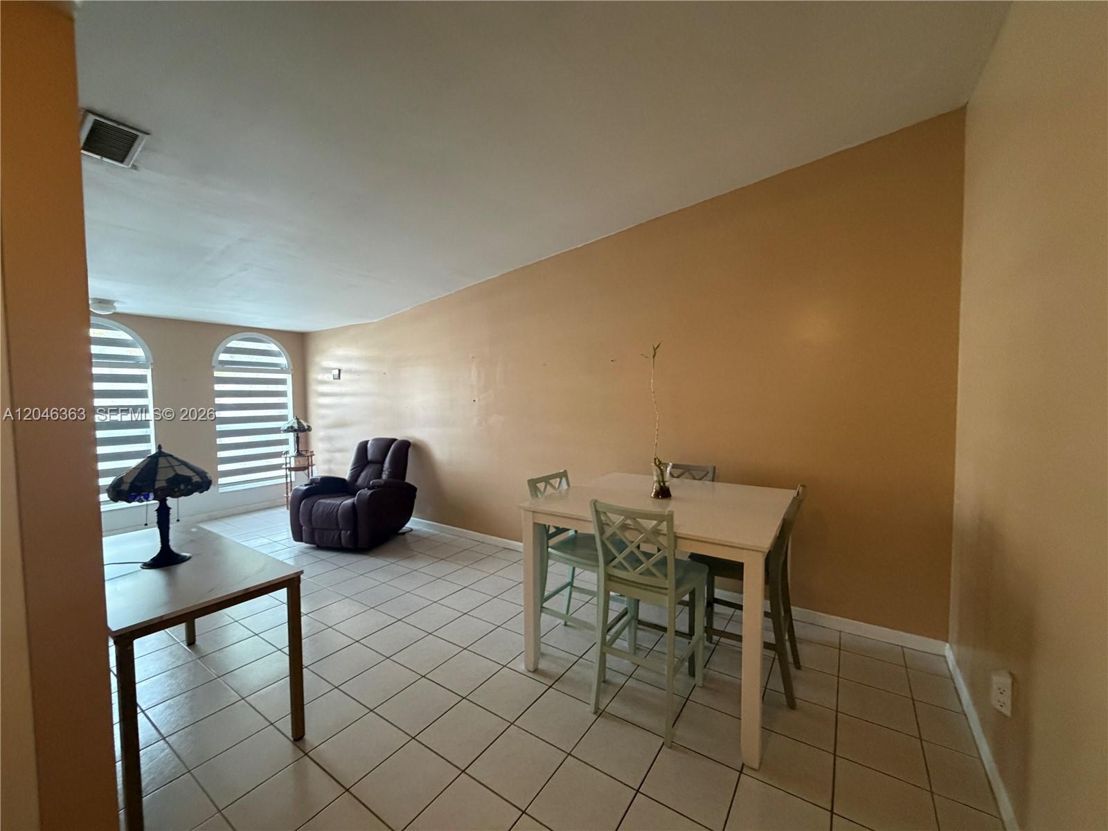 A dining area with a white table and chairs sits on a tiled floor — 6718 NW 166th Ter # 301, Miami Lakes FL 33014, MIAMI LAKES, FL