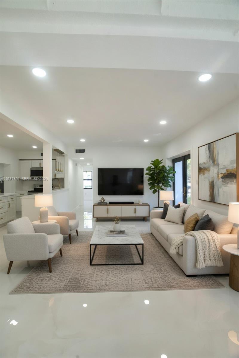 A modern living room features a white sofa, two armchairs, a marble coffee table, and a television — 315 NW 127th St, North Miami FL 33168, NORTH MIAMI, FL