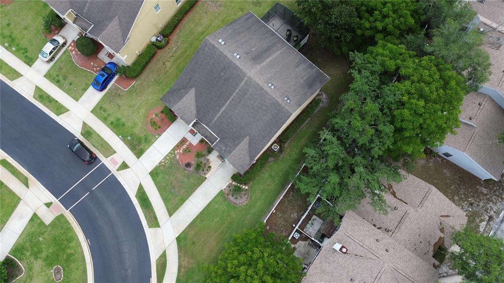 An aerial view shows a suburban house with a dark roof, driveway, and surrounding landscaping — 1111 PETERSON PLACE, SANFORD, FL
