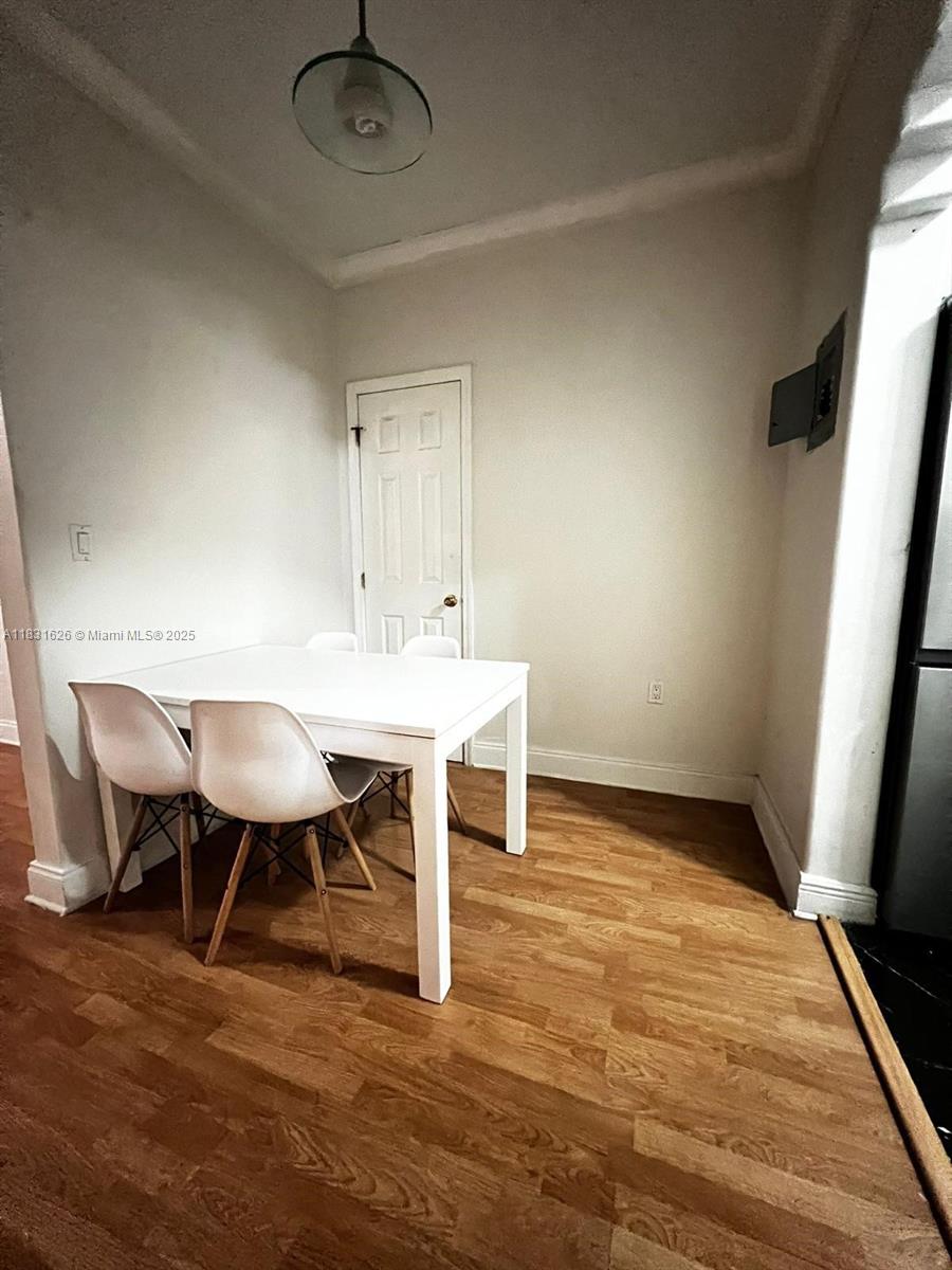 A dining area features a white table, four chairs, and wood-look flooring — 1227 Euclid Ave # 6, Miami Beach FL 33139, MIAMI BEACH, FL