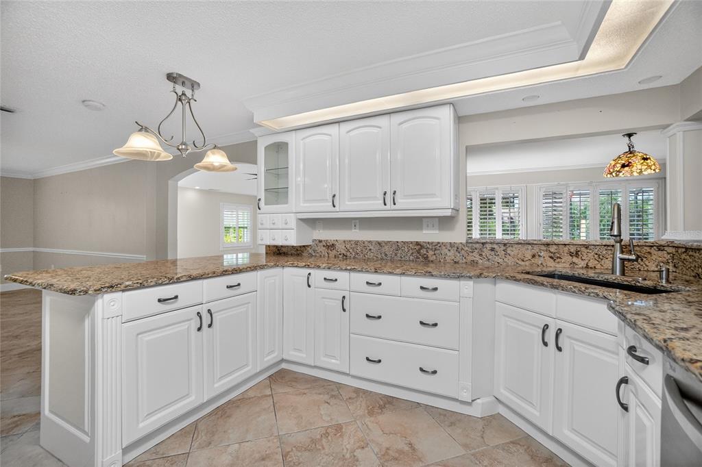 A kitchen with white cabinets, granite countertops, and a peninsula in an open floor plan — 14494 LILLIAN CIRCLE, PORT CHARLOTTE, FL