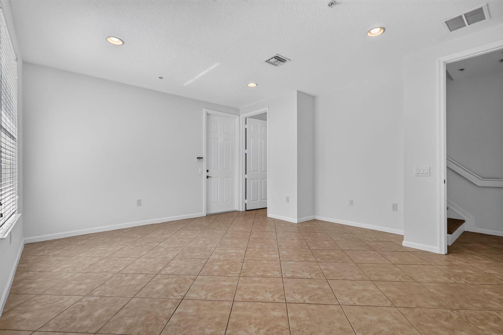 An empty room with beige tile flooring, white walls, recessed lighting, and two interior doors — 1213 Via Fatini, Boynton Beach FL 33426, BOYNTON BEACH, FL