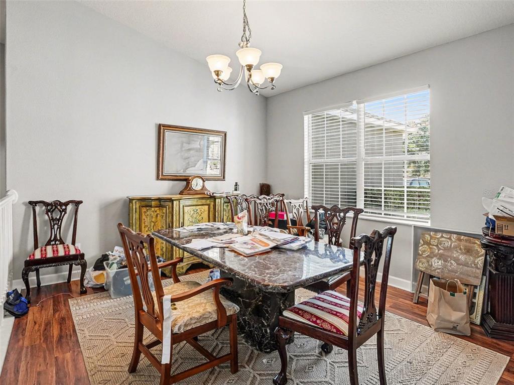 A kitchen features light wood cabinets, granite countertops, stainless steel appliances, and tile flooring — 1042 HARMONY LANE, CLERMONT, FL