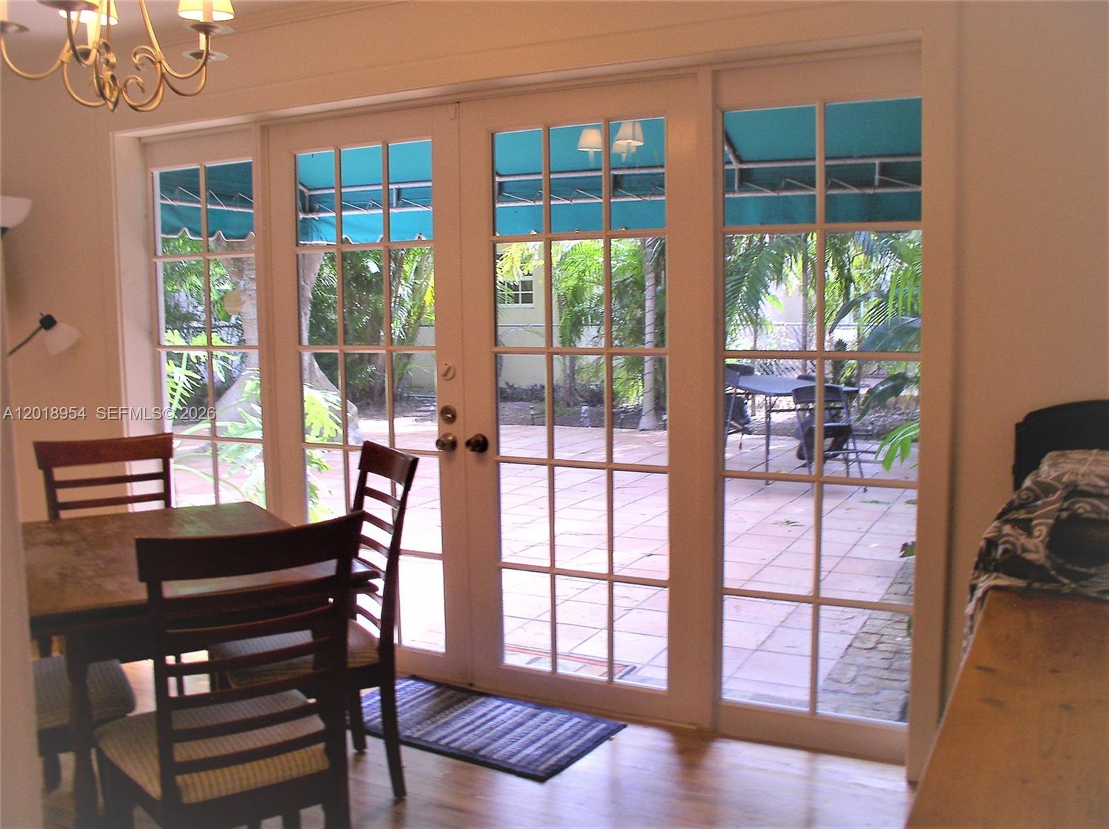 A dining area features a wooden table, chairs, and glass doors opening to a patio — 404 Viscaya Ave # 404, Coral Gables FL 33134, CORAL GABLES, FL