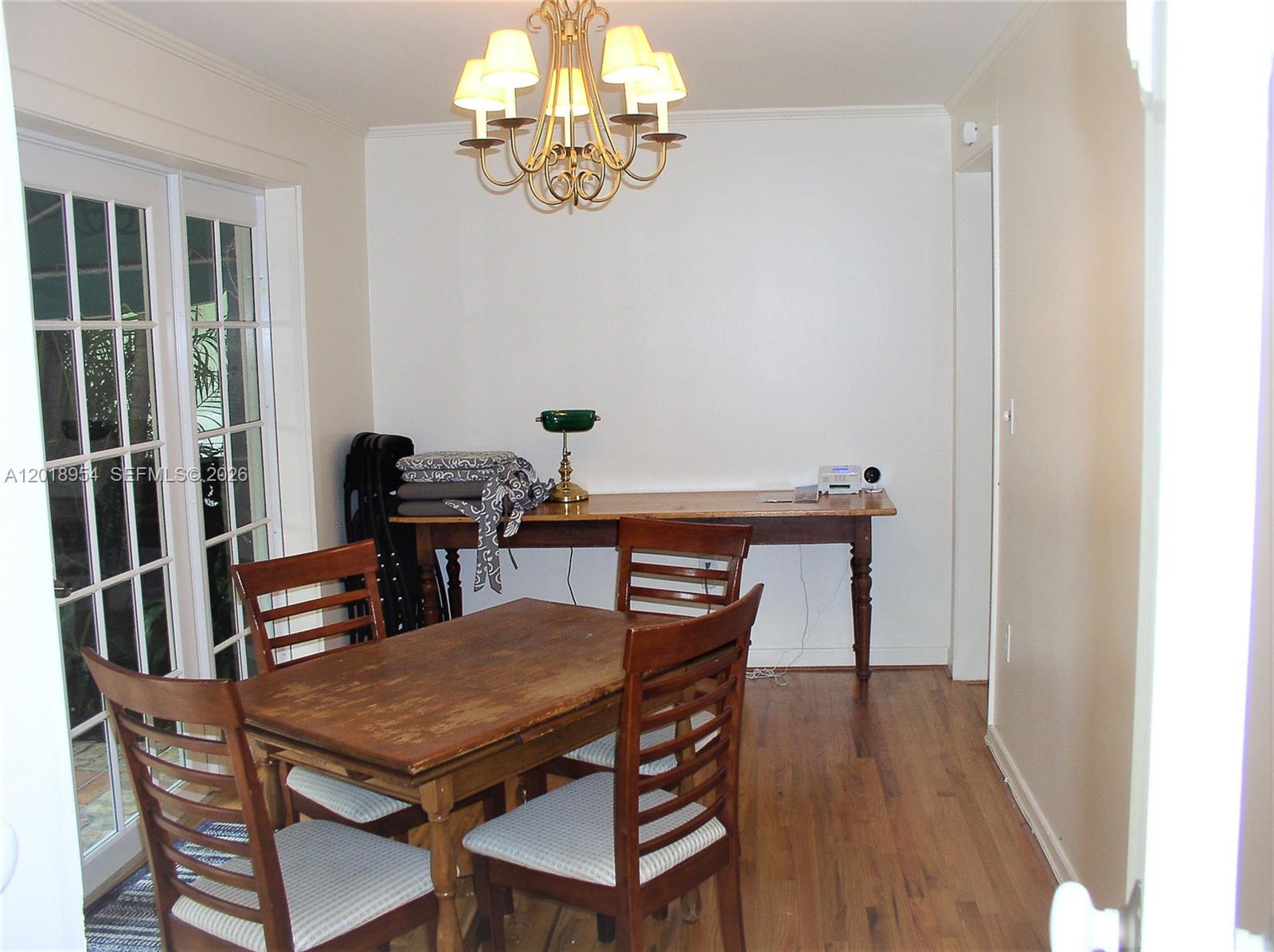 A dining room features a wooden table, chairs, a console table, and a chandelier — 404 Viscaya Ave # 404, Coral Gables FL 33134, CORAL GABLES, FL