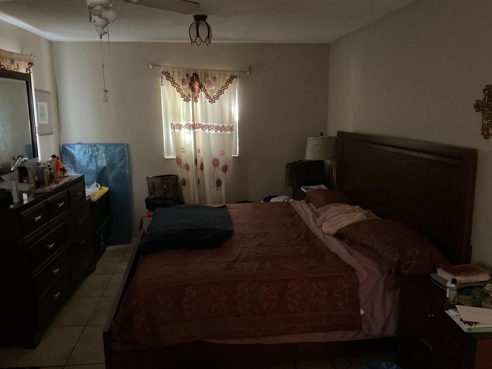 A bedroom features a dark wood bed frame, a matching dresser with a mirror, and curtains — 1433 NE 26th Court, Pompano Beach FL 33064, POMPANO BEACH, FL