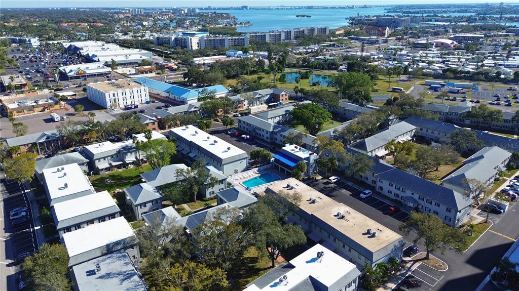 An aerial view shows a multi-building apartment complex with a central swimming pool — 6930A PLACE DE LA PAIX UNIT 2B, SOUTH PASADENA, FL