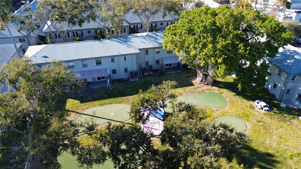 An aerial view shows a multi-unit apartment building with a small putting green courtyard — 6930A PLACE DE LA PAIX UNIT 2B, SOUTH PASADENA, FL
