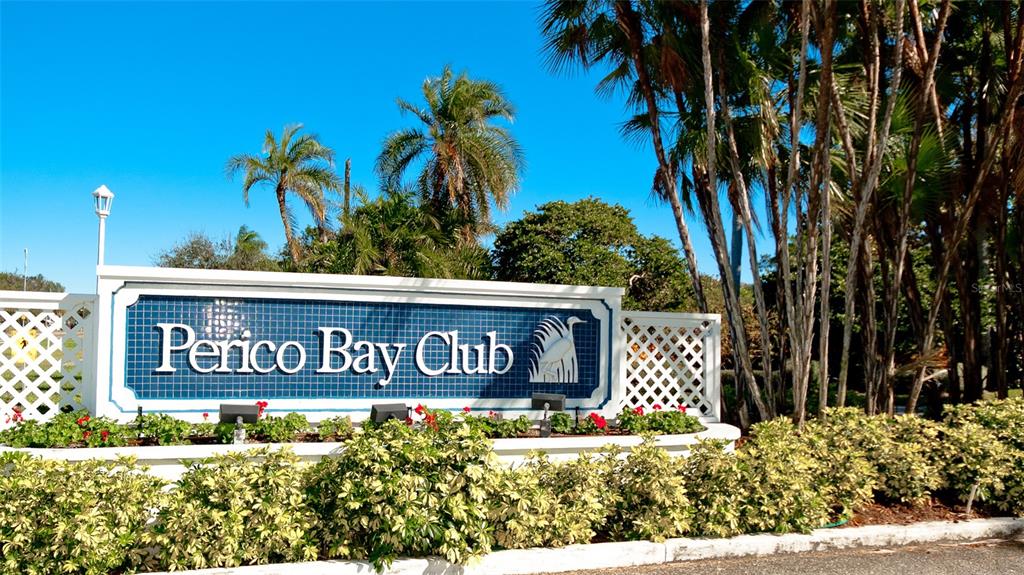 A blue and white sign for Perico Bay Club stands behind a landscaped garden — 504 WOODSTORK CIRCLE, BRADENTON, FL