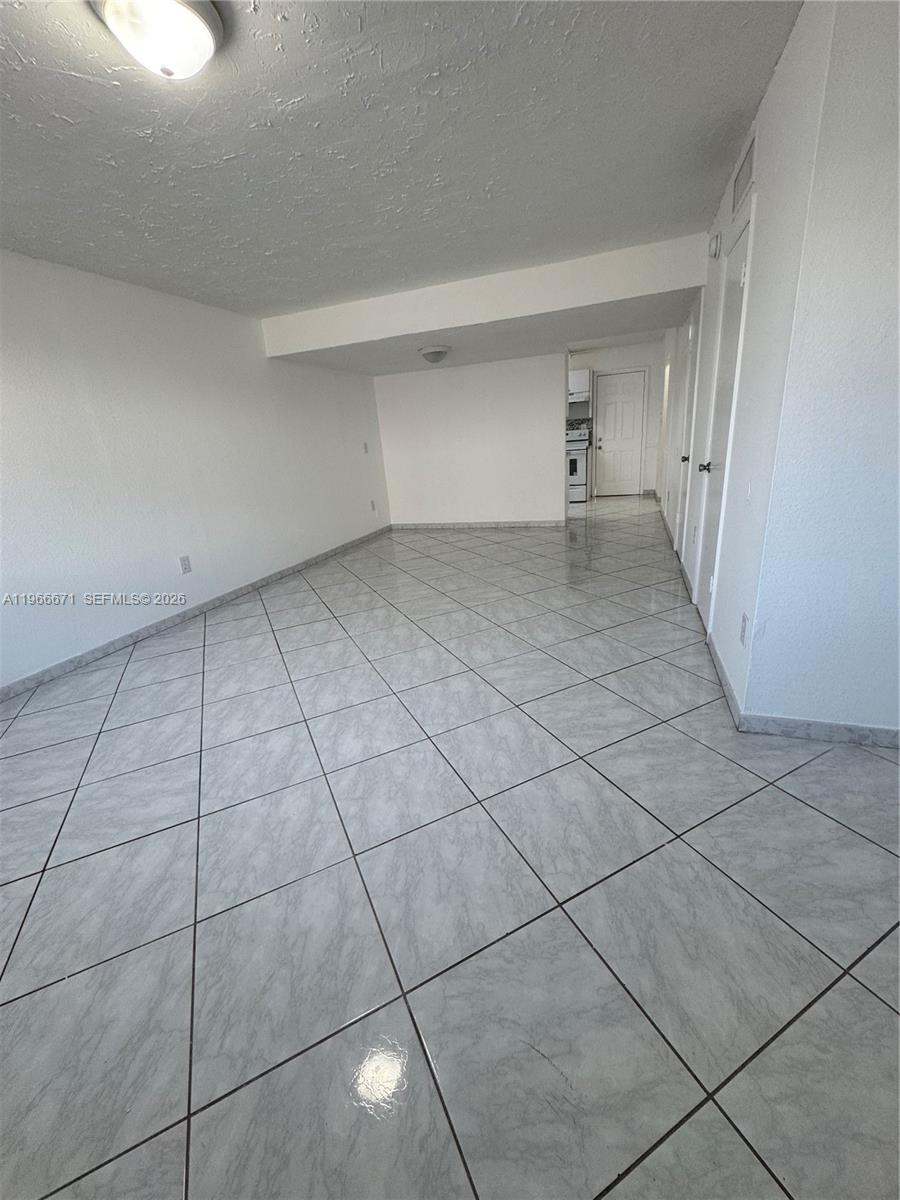This room features white walls, a tiled floor laid on a diagonal, and recessed lighting — 1481 NE 150th St # 102, Miami FL 33161, MIAMI, FL