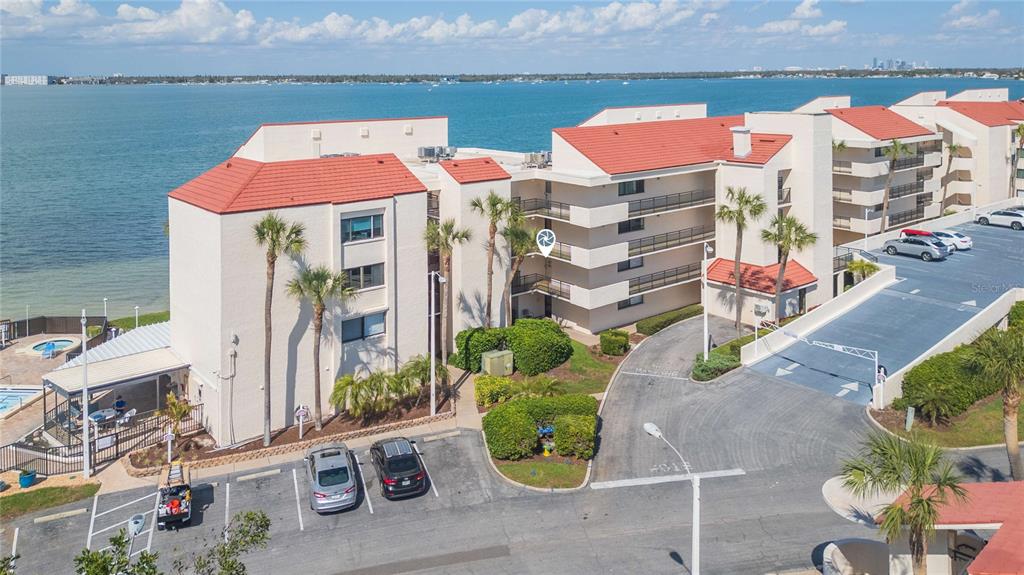 An aerial view of a multi-story waterfront condominium building with a parking lot and pool — 5633 PUERTA DEL SOL BOULEVARD S UNIT 204, ST PETERSBURG, FL