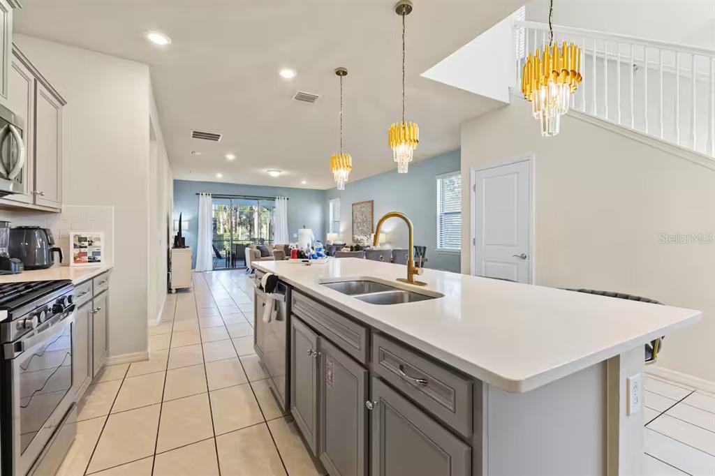 A kitchen with gray cabinets, a white quartz island, and gold pendant lighting — 5405 MISTY OAK CIRCLE, DAVENPORT, FL