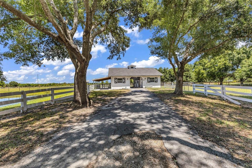 An aerial view shows a fenced residential property with mature trees and a driveway — 5222 BLACKJACK CIRCLE, PUNTA GORDA, FL