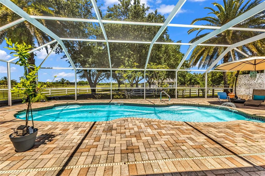 A gated driveway leads to a house surrounded by large trees and white picket fencing — 5222 BLACKJACK CIRCLE, PUNTA GORDA, FL