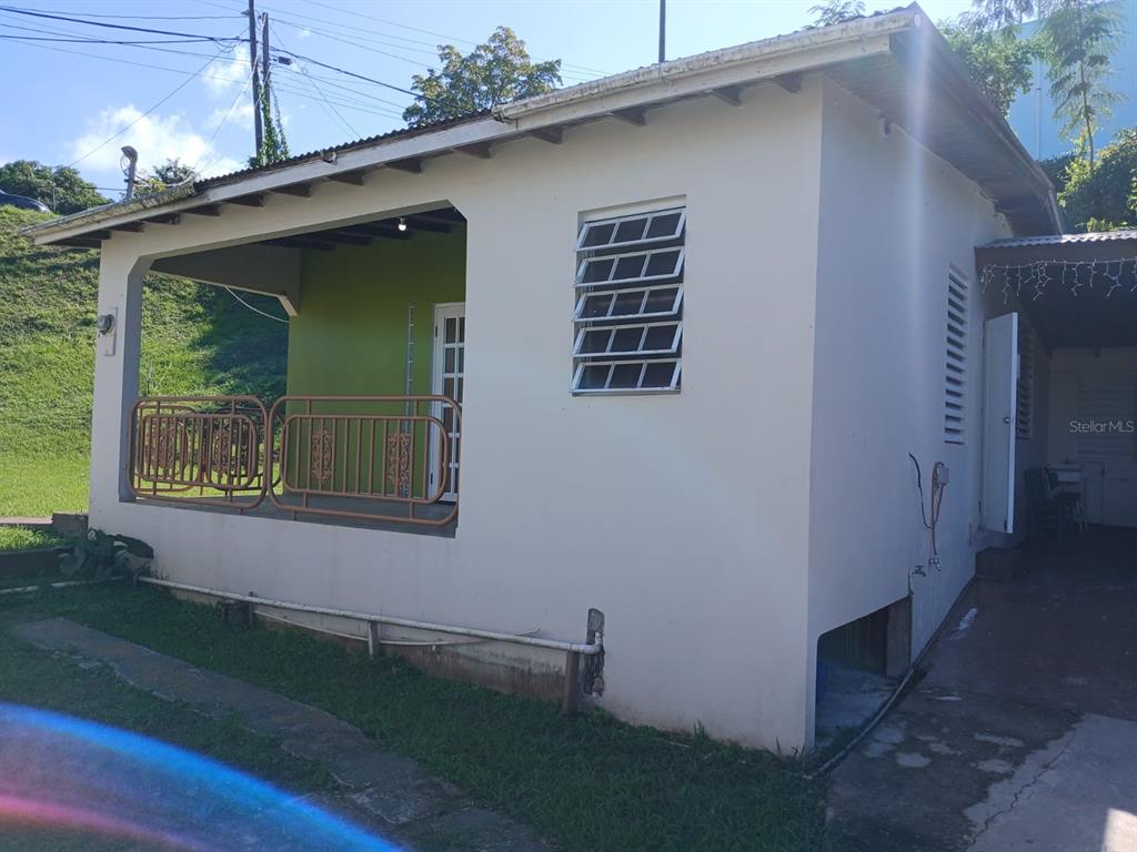 A small, light-colored house features a covered porch with a green wall and metal railings — 600 Pascual Valle CALLE PASCUAL VALLE CASTILLO, MAYAGUEZ, PR