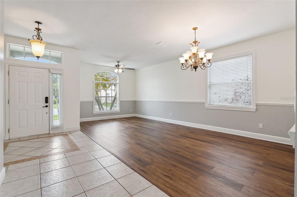 A living room with wood flooring, a chandelier, a ceiling fan, and a tiled entryway — 520 TUTEN TRAIL, ORLANDO, FL