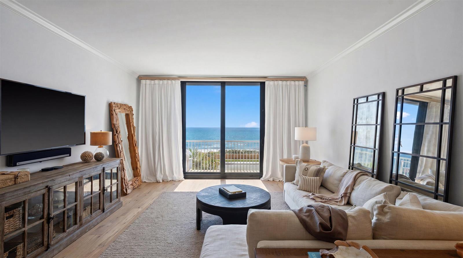 A living room features a sectional sofa, a television console, and sliding doors overlooking the ocean — 400 S Ocean Boulevard # 216, Palm Beach FL 33480, PALM BEACH, FL