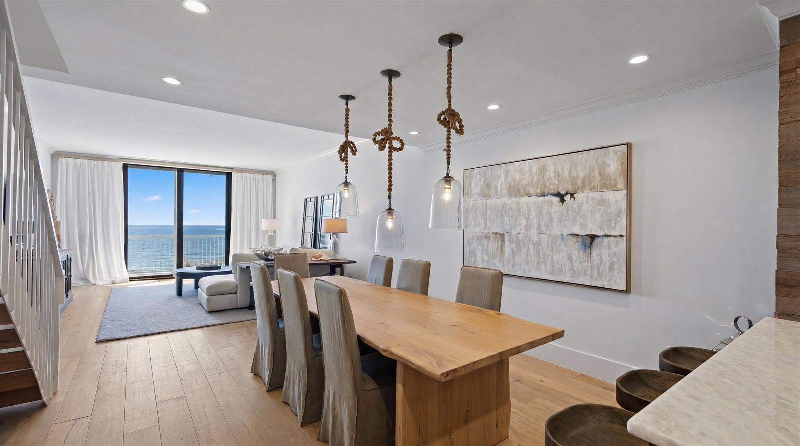 A dining area with a wooden table, rope pendant lights, and a view of the ocean — 400 S Ocean Boulevard # 216, Palm Beach FL 33480, PALM BEACH, FL