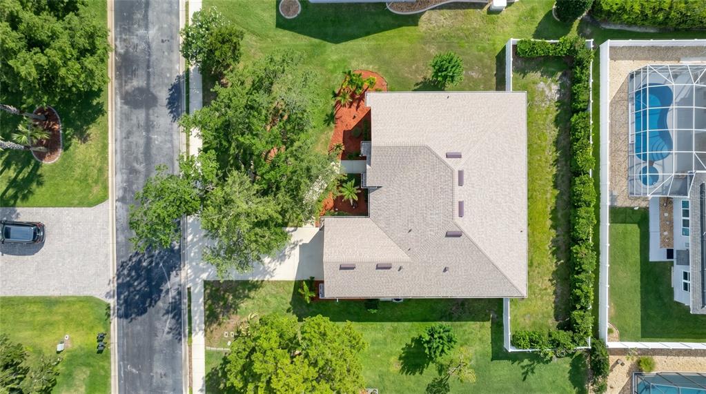 An aerial view shows a house with a shingled roof, surrounding lawn, and landscaping — 736 ALDENWOOD TRAIL, NEW SMYRNA BEACH, FL
