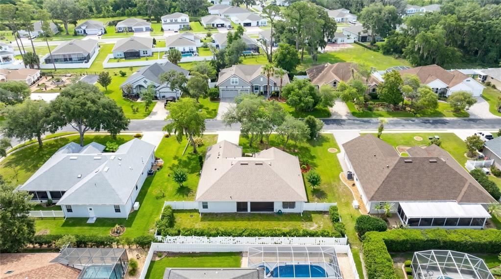 An aerial view shows several suburban houses with fenced backyards and swimming pools — 736 ALDENWOOD TRAIL, NEW SMYRNA BEACH, FL