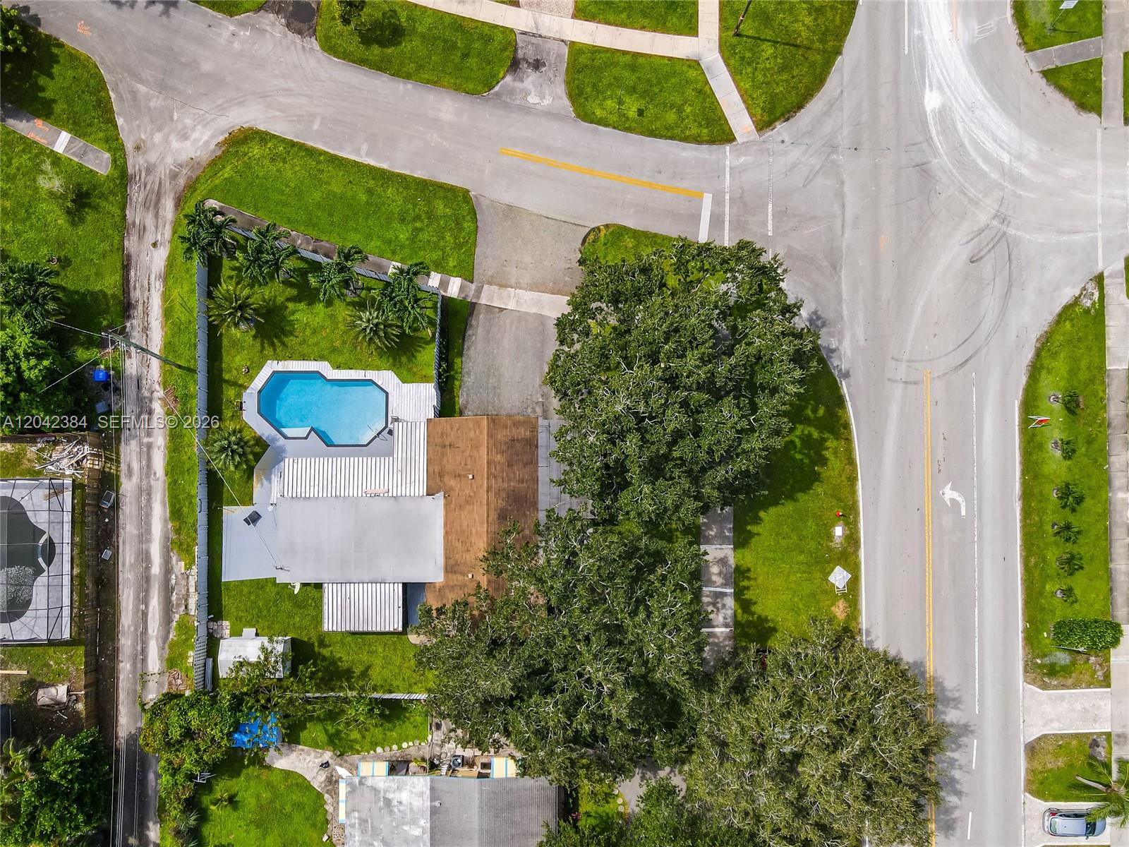 An aerial view shows a house with a swimming pool and large trees on a corner lot — 3338 Taft St, Hollywood FL 33021, HOLLYWOOD, FL