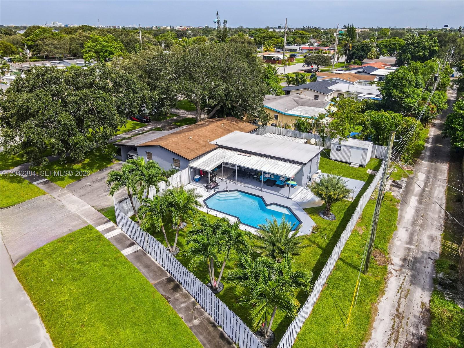 An aerial view shows a house with a swimming pool and a white fence — 3338 Taft St, Hollywood FL 33021, HOLLYWOOD, FL