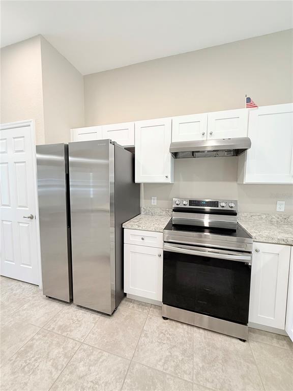 A kitchen features white cabinets, stainless steel appliances, and light-colored countertops — 15712 SW 37TH CIRCLE, OCALA, FL