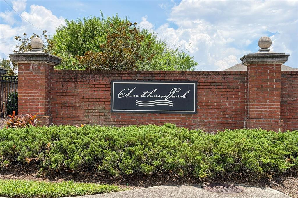 A brick entrance sign for Anthem Park sits behind a manicured green hedge — 1831 CENTENNIAL AVENUE, ST CLOUD, FL