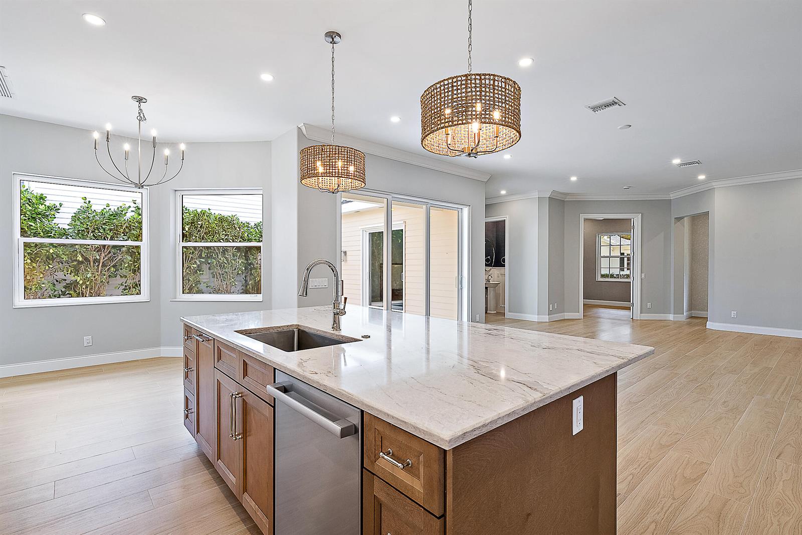 A kitchen island with a stainless steel sink and dishwasher sits in a bright room — 248 Honeysuckle Drive, Jupiter FL 33458, JUPITER, FL