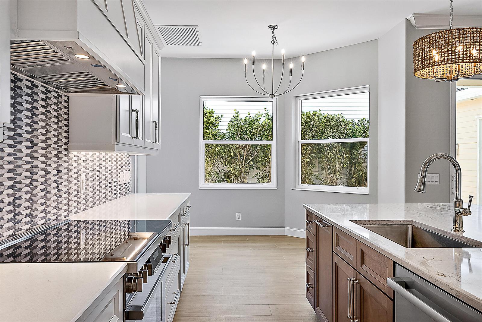 A kitchen features white cabinets, a patterned backsplash, a brown island, and a dining nook — 248 Honeysuckle Drive, Jupiter FL 33458, JUPITER, FL