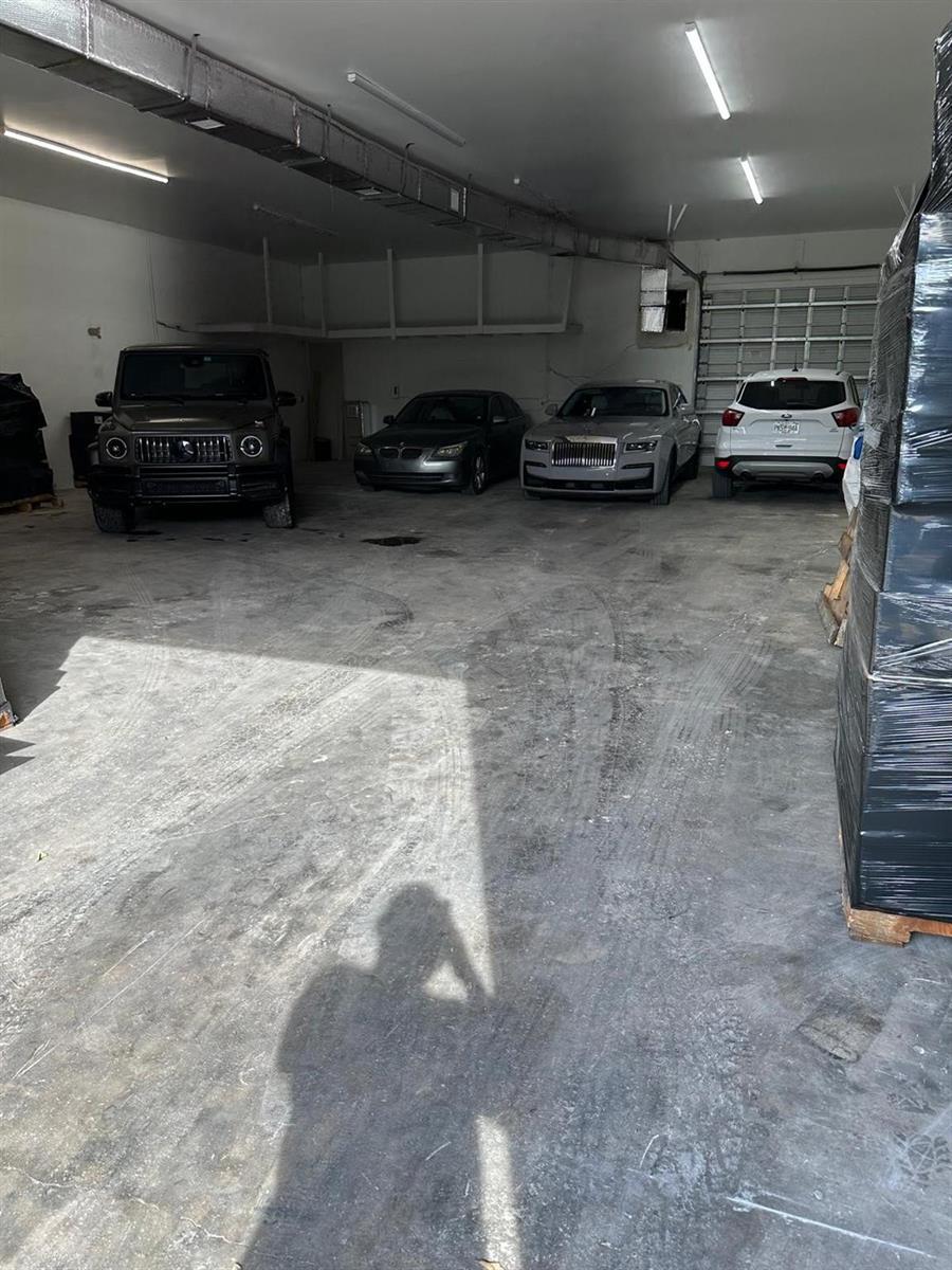 A large, industrial-style garage with concrete floors houses four parked vehicles — 3300 Burris Road, Davie FL 33314, DAVIE, FL