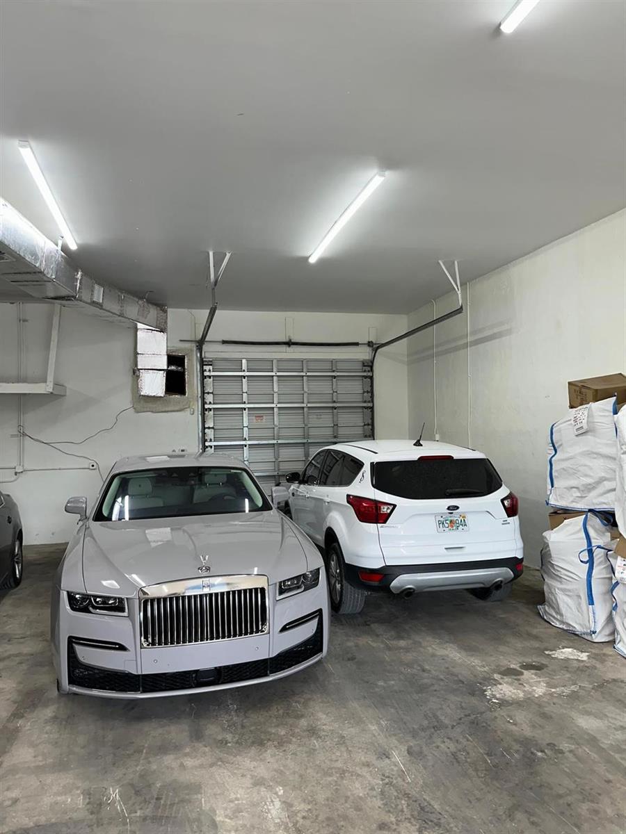 A garage contains a grey Rolls-Royce, a white Ford SUV, and large storage bags — 3300 Burris Road, Davie FL 33314, DAVIE, FL
