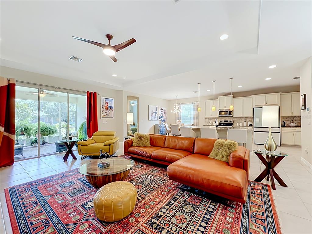 A living room features a large leather sectional, a patterned rug, and a television console — 25224 LAHORE LANE, PUNTA GORDA, FL