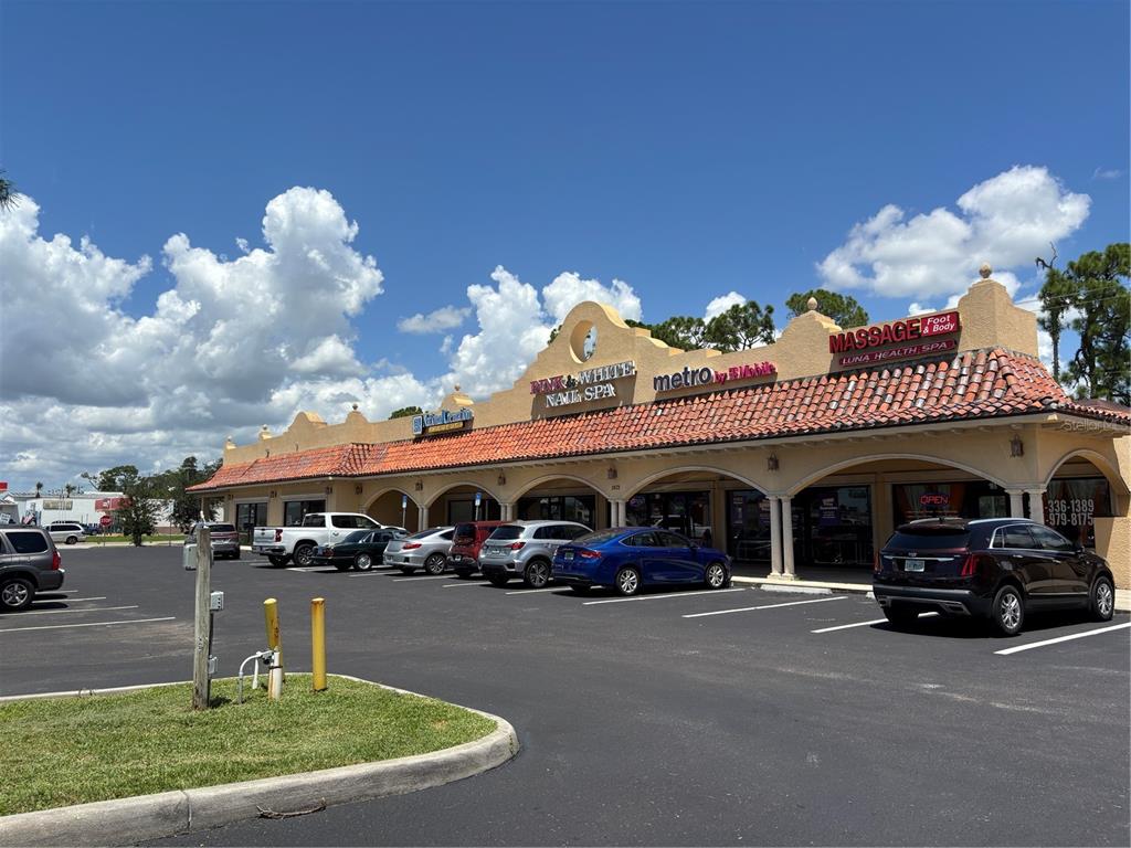 A single-story commercial strip mall with a tiled roof and several parked cars — 2672-2686 TAMIAMI TRAIL UNIT 6B,7B, PORT CHARLOTTE, FL