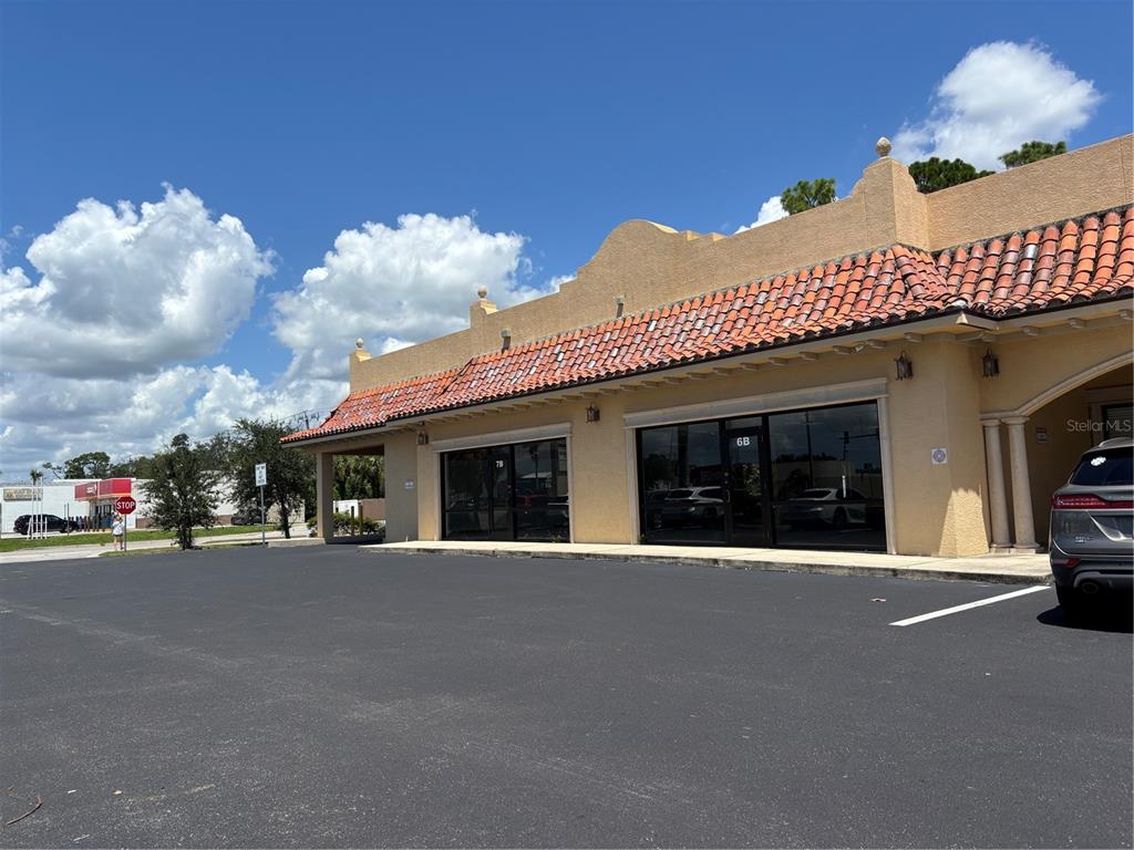 A commercial building exterior features a stucco facade, a red tile roof, and glass storefronts — 2672-2686 TAMIAMI TRAIL UNIT 6B,7B, PORT CHARLOTTE, FL