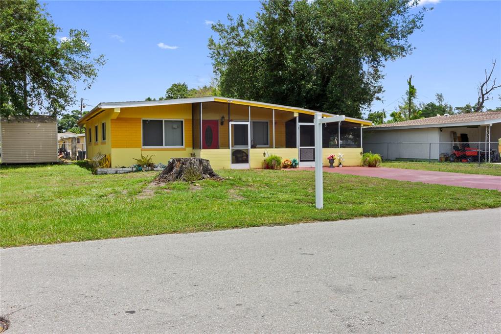 A yellow single-story house with a screened-in front porch sits on a grassy lot — 3741 BELL STREET, FORT MYERS, FL