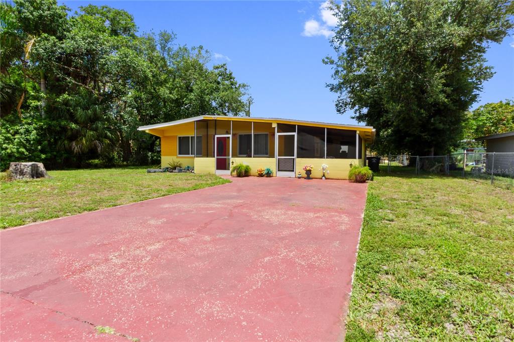 A yellow single-story house with a screened-in front porch and a red concrete driveway — 3741 BELL STREET, FORT MYERS, FL