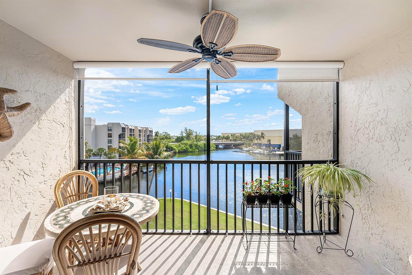 A screened-in balcony features a ceiling fan, a small dining set, and a water view — 7 Royal Palm Way # 507, Boca Raton FL 33432, BOCA RATON, FL
