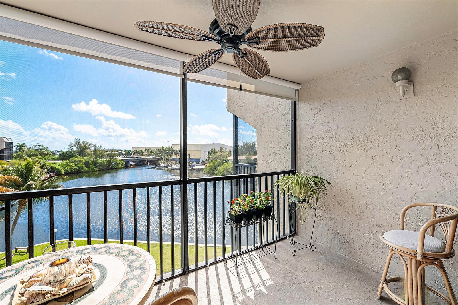 A screened-in balcony features a ceiling fan, a round table, and a view of water — 7 Royal Palm Way # 507, Boca Raton FL 33432, BOCA RATON, FL