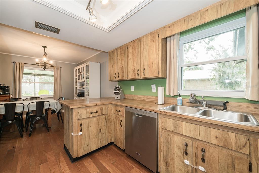 A kitchen with wood cabinets, a stainless steel dishwasher, and a green backsplash — 1404 REDBUD CIRCLE, PLANT CITY, FL