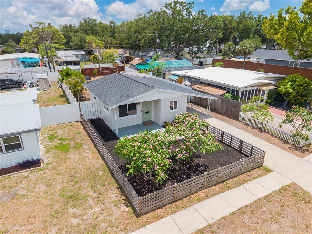 An aerial view shows a small, light-colored house with a front yard featuring flowering trees — 710 50TH AVENUE N, ST PETERSBURG, FL