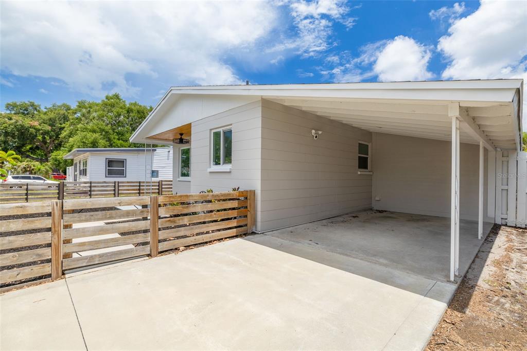 A light-colored house exterior features a concrete driveway and an attached covered carport — 710 50TH AVENUE N, ST PETERSBURG, FL