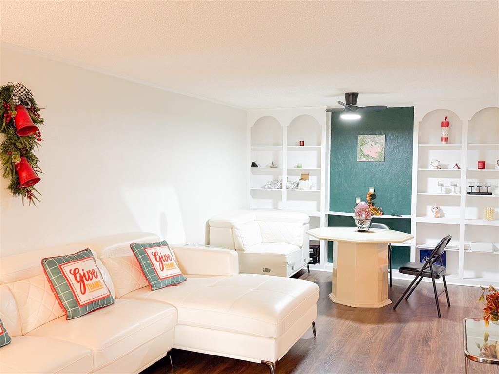 A living room features a white sectional sofa, a dining table, and built-in white shelving — 4219 E MICHIGAN STREET UNIT 4219, ORLANDO, FL