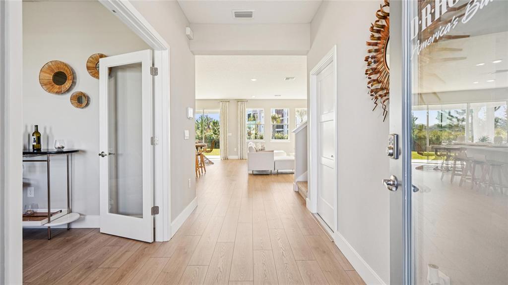 A bright entryway leads into an open-concept living area with light wood-look flooring — 4249 SW 52ND LANE ROAD, OCALA, FL