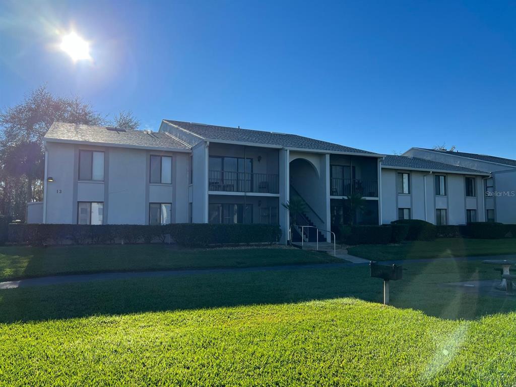A two-story apartment building with a gray exterior and a grassy lawn in front — 1324 S PINE RIDGE CIRCLE UNIT D2, SANFORD, FL