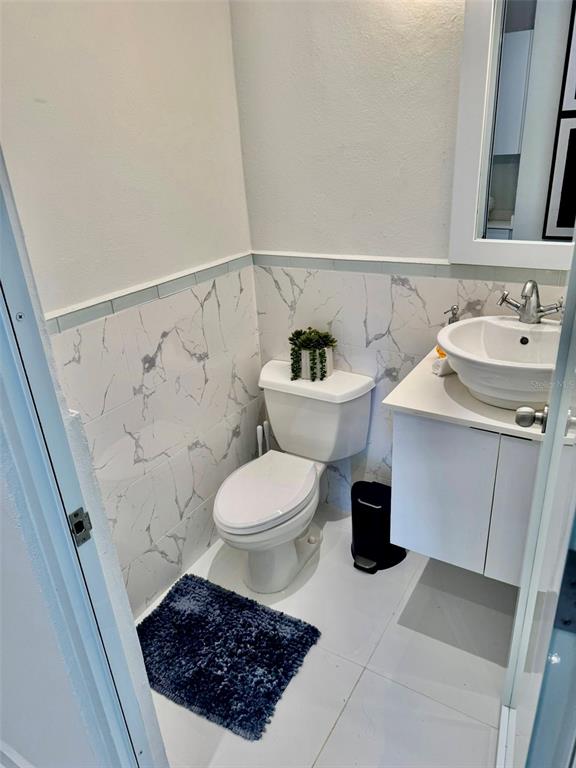 A small bathroom features a white toilet, a pedestal sink, and white marble-patterned wall tiles — A1 Harbour Lakes A1 HARBOUR LAKES PALMAS DR UNIT A1, HUMACAO, PR