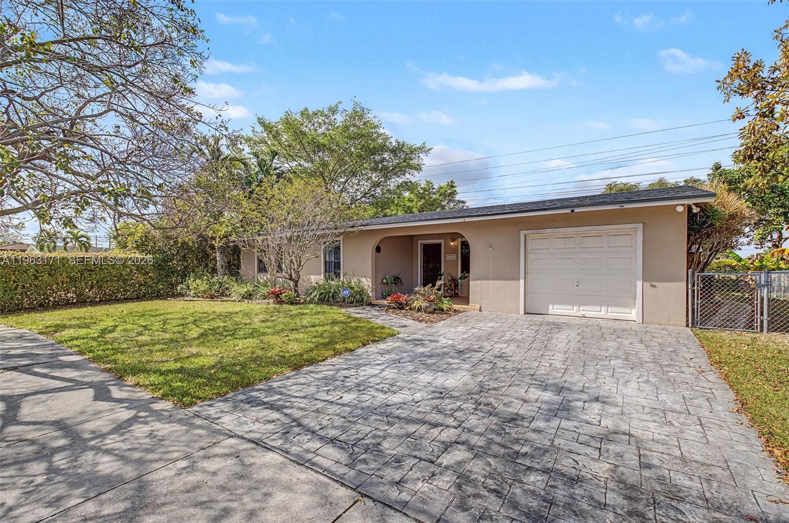 A single-story house with a beige stucco exterior, a paved driveway, and a one-car garage — 7354 SW 135th Ct, Miami FL 33183, MIAMI, FL